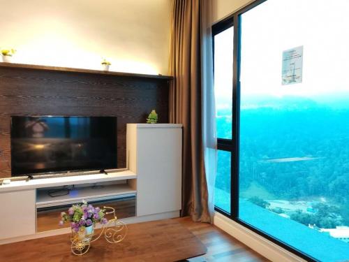 a living room with a large window and a television at Geo 38 Residence Genting Highland in Genting Highlands