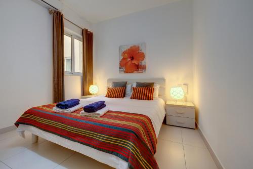 ein Schlafzimmer mit einem Bett mit zwei Handtüchern darauf in der Unterkunft Modern Apartment steps from Balluta Bay in Sliema