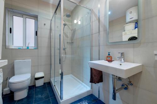 La salle de bains est pourvue de toilettes, d'un lavabo et d'une douche. dans l'établissement Unbeatable Location Valletta and Harbour views, à Sliema