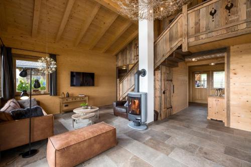 - un salon avec un canapé et une cheminée dans l'établissement Narzenhof Wellness Chalets, Familien & Luxus Apartments am Bauernhof, à St. Johann in Tirol