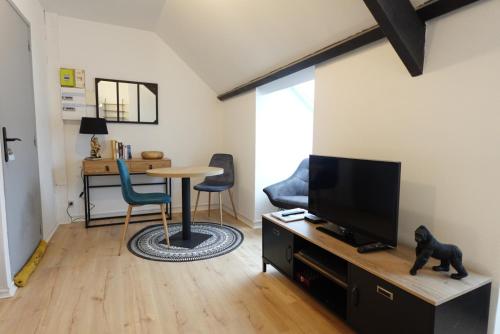 a living room with a television and a table at Studio - Centre - Fac de Science in Lens