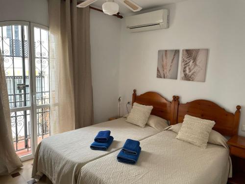 een slaapkamer met twee blauwe handdoeken op een bed bij Verano Azul 12 Menyber in Nerja