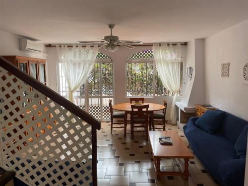 een woonkamer met een tafel en een blauwe bank bij Verano Azul 12 Menyber in Nerja