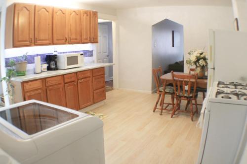 cocina con armarios de madera y mesa con microondas en 3 BR Southside Pad - Sleeps 8 - Amazing Location, en Pittsburgh