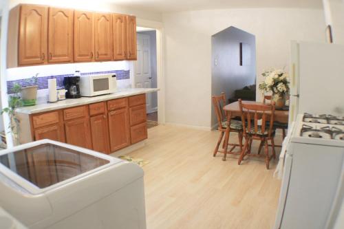 a kitchen with wooden cabinets and a table with a microwave at 3 BR Southside Pad - Sleeps 8 - Amazing Location in Pittsburgh