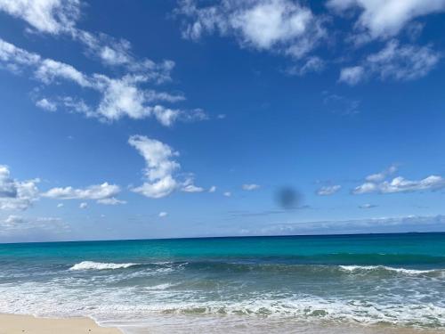 a beach with a blue sky and the ocean at Seaside Two-Bedroom Chalet Sidi Krir in Sidi Krir 