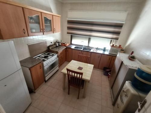 a small kitchen with a table and a refrigerator at Sweet aqaba apartment in Aqaba