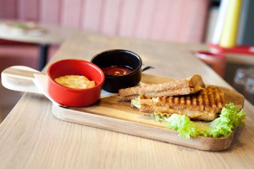 a wooden plate with a sandwich and a bowl of dipping sauce at greet Wien City Nord in Vienna