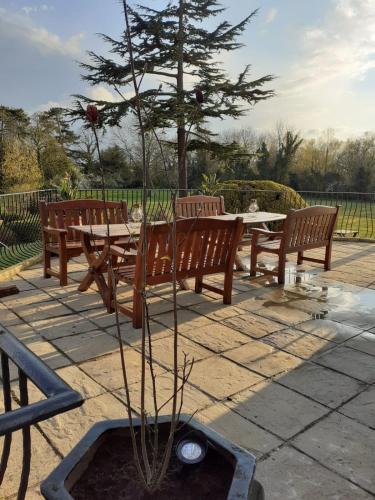 a tree in a fountain next to a table and benches at The Manor at Bickley in Bromley
