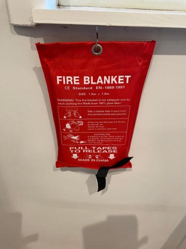 a red fire blanket hanging on a wall at Loft apartment in Joppa in Edinburgh