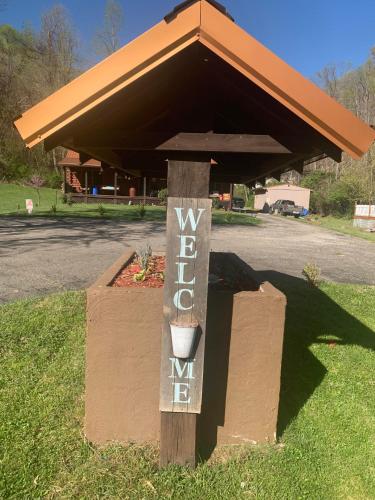 a sign on a post in front of a building at Log Cabin in the Field in Huntington