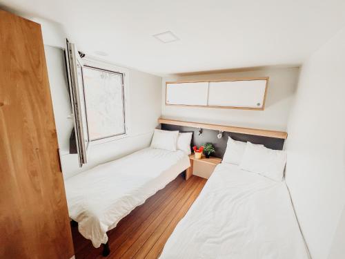two beds in a small room with a window at Diamond Coast Mobile Home in Drage