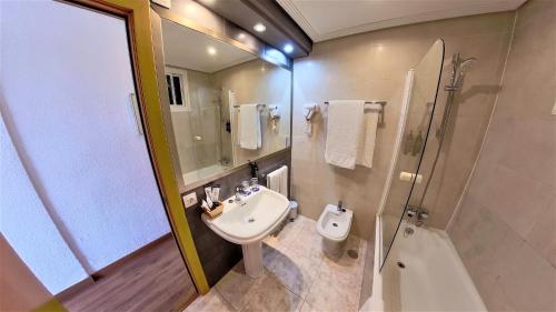 y baño con lavabo, ducha y aseo. en Ohtels Gran Hotel Almeria, en Almería