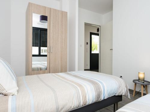 a bedroom with a bed and a mirror at Maison Arcachon, 3 pièces, 5 personnes - FR-1-420-63 in Arcachon