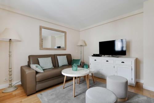 uma sala de estar com um sofá e uma mesa em Amazing duplex 4P- Louvre Museum em Paris