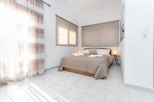 a bedroom with a bed and a window at En Plo Beachfront Rooms in Falasarna