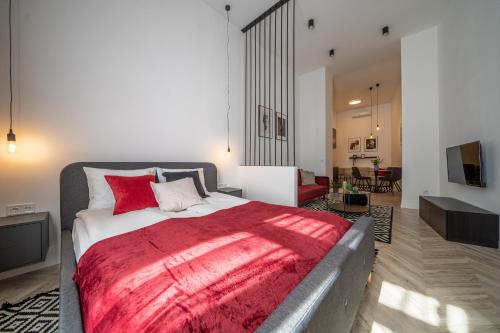 1 dormitorio con 1 cama grande con manta roja en K33- Boutique Apartments, Best Location, by BQA en Budapest