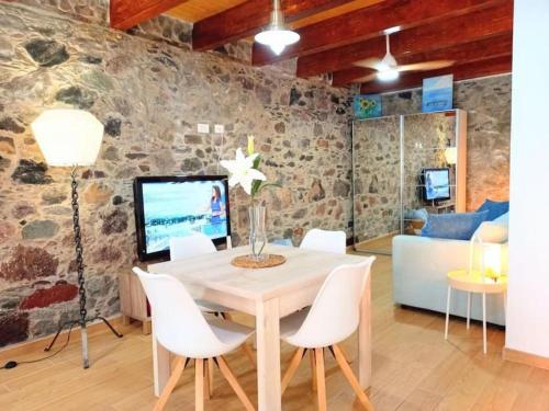 a dining room with a table and white chairs at Estudio El Ingenio de San Andrés in San Andrés