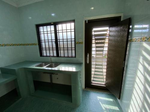 a bathroom with a sink and a window at Happiness Homestay in Mersing