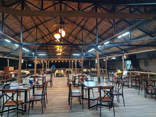 - Zona de comedor con mesas y sillas en un edificio en Wildbird Hotel en Tràm Chim