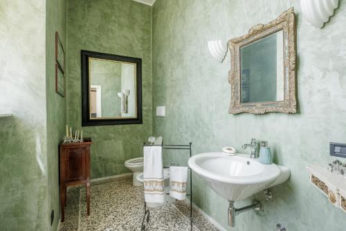 Un baño con lavabo, espejo e inodoro. en Villa Landi, en Lucca