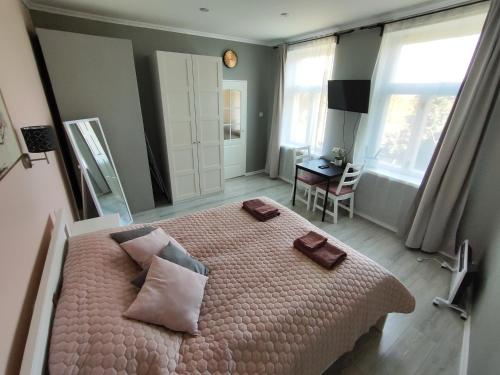 una camera da letto con un grande letto con lenzuola e cuscini rosa di Mezrozes a Ventspils