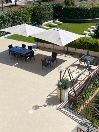 a patio with tables and white umbrellas at Villa Cinque in Vico Equense