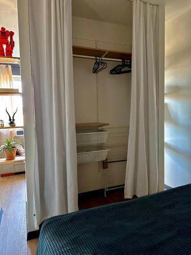 a bedroom with a bed and a white curtain at Cosy place in small town in Maardu