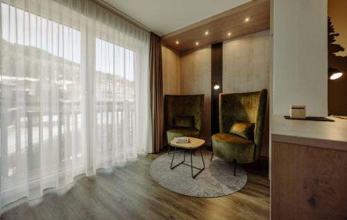 a room with two chairs and a table and a window at Hotel Waldfrieden in Schladming