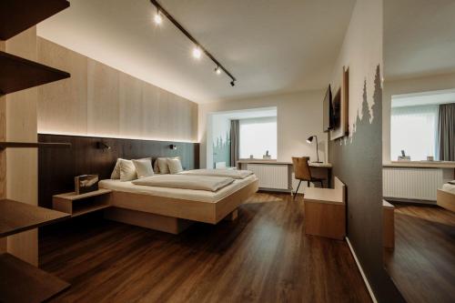 a large bedroom with a bed and wooden floors at Hotel Waldfrieden in Schladming