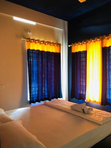 a bedroom with a large bed with windows at Royal residency in Tindummal