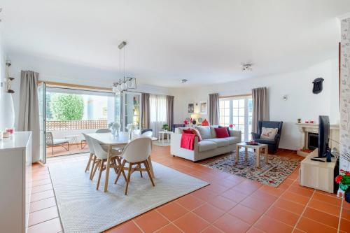 a living room with a table and chairs and a couch at Apartamento T3 Praia D'el Rey in Casal da Lagoa Seca