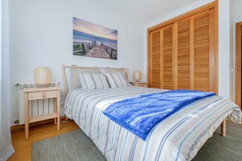1 dormitorio con cama y armario de madera en Apartamento T3 Praia D'el Rey, en Casal da Lagoa Seca