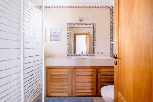 y baño con lavabo y espejo. en Apartamento T3 Praia D'el Rey, en Casal da Lagoa Seca