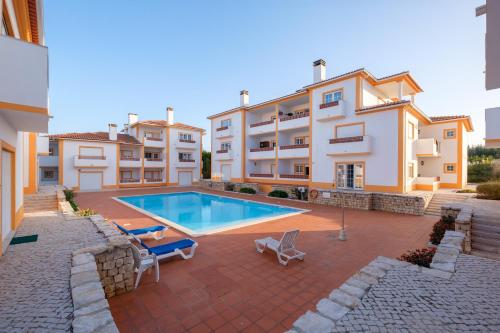 a swimming pool in front of a building at Apartamento T3 Praia D'el Rey in Casal da Lagoa Seca