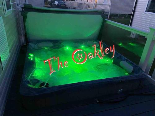 a neon sign that says theoda in a bathtub at Tattershall Lakes The Oakley Caravan 8 berth, Hot tub & WiFi in Tattershall