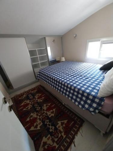 Dormitorio pequeño con cama y alfombra en Arko sitesi, en Karaburun