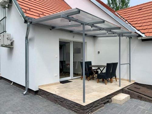 awning over a patio with a table and chairs at Nono Apartman Bükfürdő in Bükfürdő