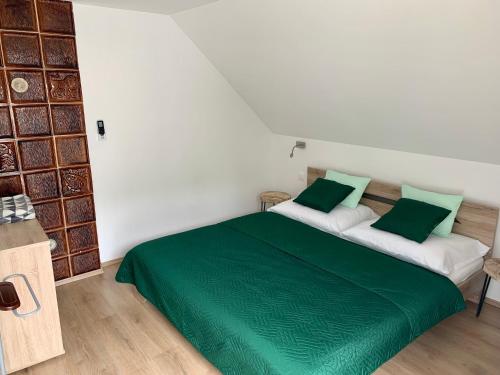 a bedroom with two beds with green and white at Nono Apartman Bükfürdő in Bükfürdő