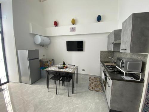 a kitchen with a table and a refrigerator at NobileHouse in Catania