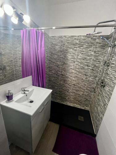 a bathroom with a sink and a purple shower at CASA DOMINGO 3 in La Santa