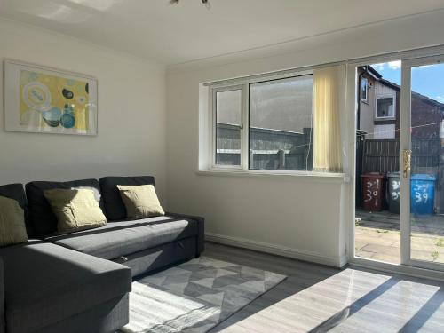 a living room with a couch and a window at BEA Allenby Walk in Manchester