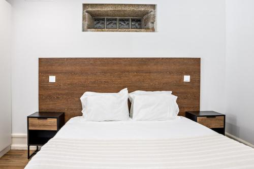 1 dormitorio con 1 cama blanca y 2 mesitas de noche en Casa do Mestre Studio, en Vila de Punhe
