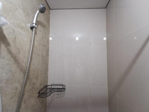 La salle de bains est pourvue d'une douche et d'une porte en verre. dans l'établissement ARSAKHA 004 Transpark Cibubur By Nigiri Amour, à Kalimanggis