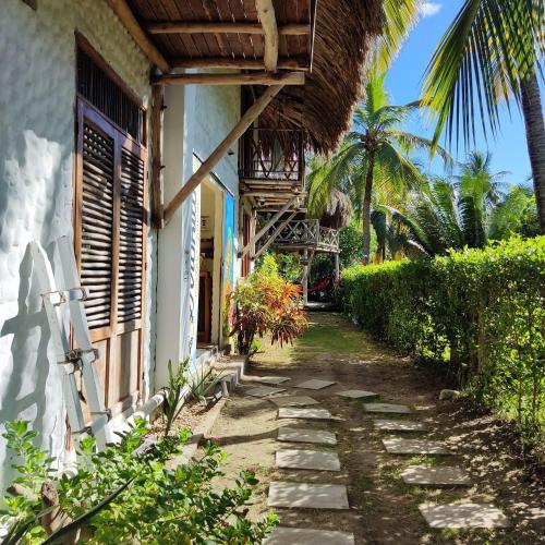 a house with a pathway next to a building at Maria Moñitos Hostel in Moñitos