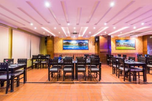 a restaurant with tables and chairs in a room at Hotel Pokhara Goodwill in Pokhara