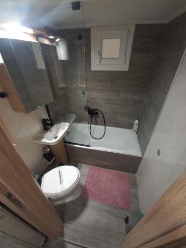a small bathroom with a toilet and a bath tub at Central 4 Modern Apartment with free parking in Serres