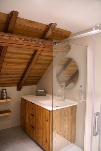une salle de bain avec un lavabo et un miroir dans l'établissement La grange au ruisseau, à Bellecombe-en-Beauges
