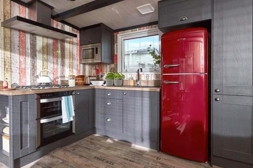 a kitchen with a red refrigerator in the middle at Mersea Island by Away Resorts in Colchester