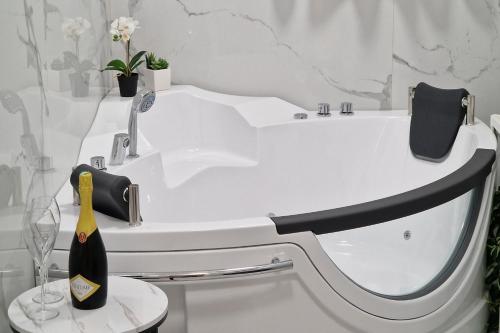 a white bath tub with a bottle of champagne on a stool at Montesan Luxury Apartment DOO ODMONTE in Sveti Stefan